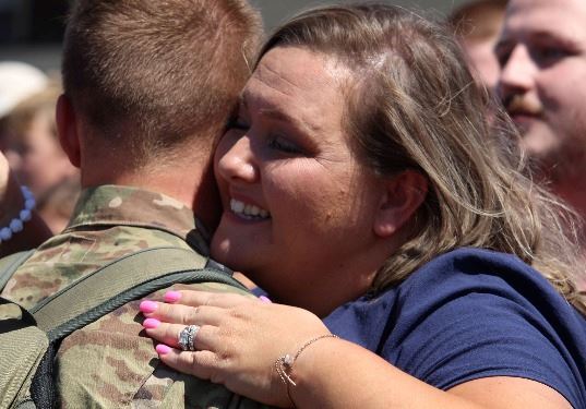 Soldier embraced by family member